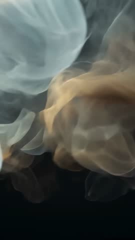 Vertical abstract smoke video forming amber and blue ribbons drifting over black backdrop