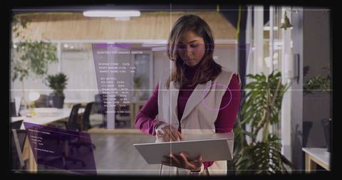 Businesswoman holding tablet, interacting with augmented reality analytics dashboard in office