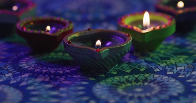 Close-up composition showing lit diyas placed on a vibrant, intricate rangoli pattern. Ideal for illustrating themes of Diwali celebrations, Indian culture, traditional rituals, and festive decorations. Suitable for articles, advertisements, and social media posts focused on the Festival of Lights.
