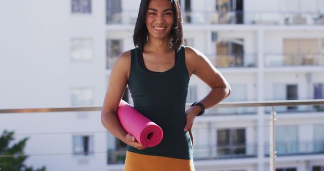 Smiling Woman Holding Yoga Mat on Balcony - Download Free Stock Images Pikwizard.com