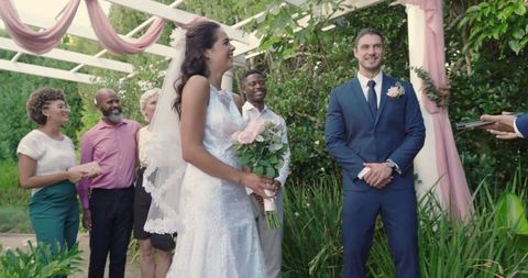 Bride and groom smiling during scenic outdoor wedding ceremony