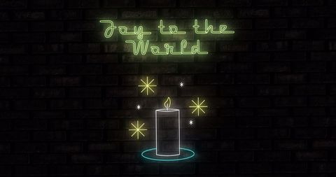 Neon candle with joyful christmas message on black brick background