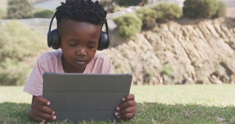 Child Engaged Learning on Tablet Outdoors with Headphones