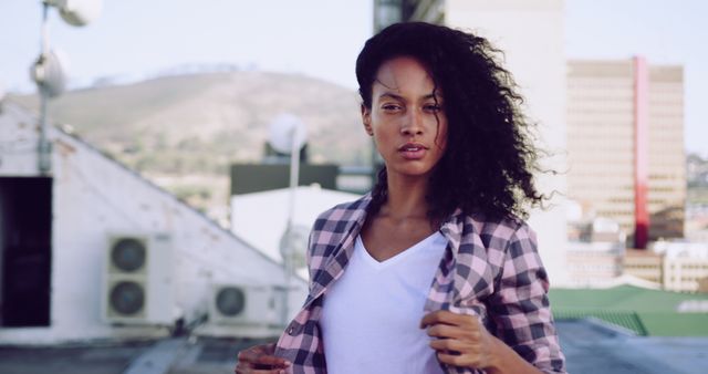 Confident Young Woman Posing on Urban Rooftop in Plaid Shirt - Download Free Stock Images Pikwizard.com