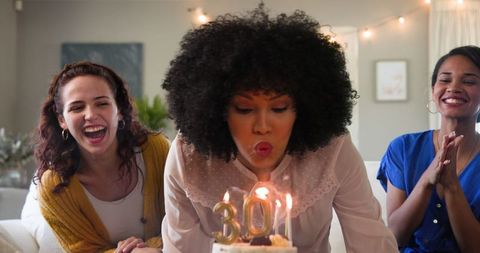 Diverse Female Friends Celebrate Birthday by Blowing Out Candles