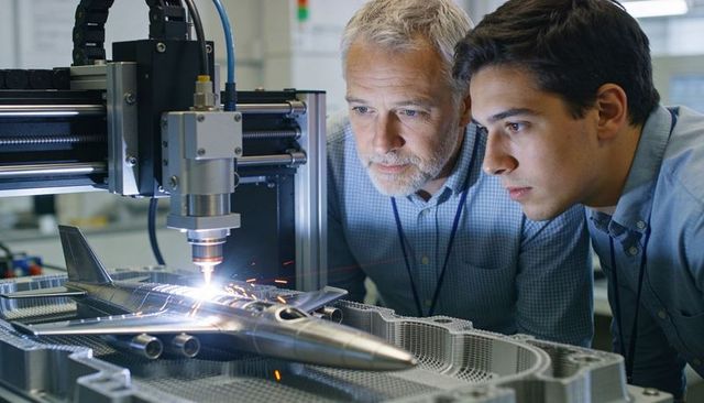 Engineers inspecting CNC laser welding on aircraft prototype, precision manufacturing