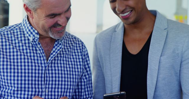 Smiling Colleagues Sharing Content on Smartphone during Work Break - Download Free Stock Images Pikwizard.com