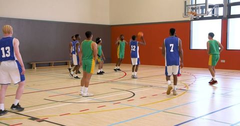 Diverse team basketball game in indoor court exciting shot