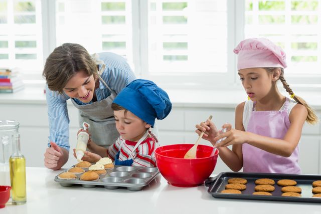 Mother and kids preparing cookies in kitchen at home