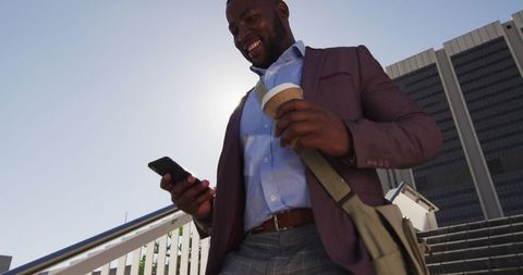 Businessman Walking Downstairs Using Smartphone