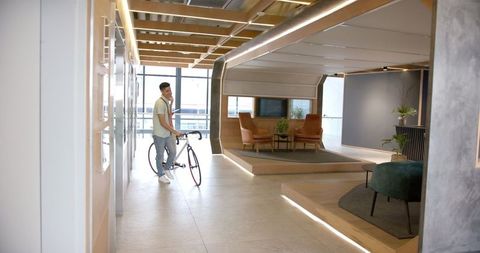 Man with Bicycle in Modern Office Environment - Download Free Stock Images Pikwizard.com