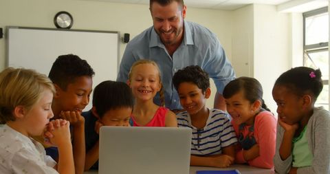 Happy Teacher Engaging with Diverse Students Using Laptop - Download Free Stock Images Pikwizard.com