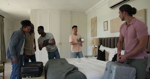 Friends Packing Luggage Before Group Trip Celebration