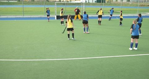Female Field Hockey Match on Turfed Stadium Setting