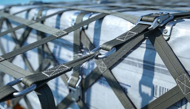 Cargo strap sparking from friction on metal d-ring while securing heavy pallet load