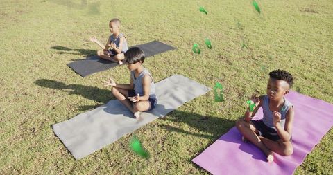 Children Meditating Outdoors With Floating Green Shapes