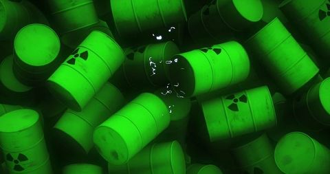 Glowing green radioactive waste barrels