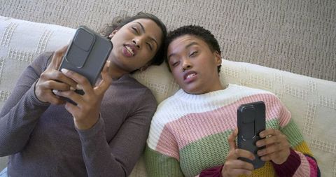 Diverse Friends Relaxing at Home with Mobile Phones