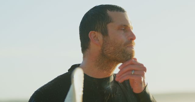 Surfer Contemplating Ocean in Wetsuit During Sunset - Download Free Stock Images Pikwizard.com