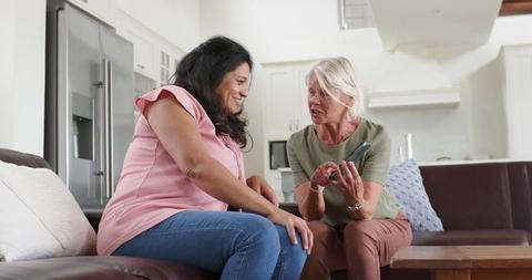 Two Senior Women Looking at Smartphone and Smiling on Sofa - Download Free Stock Images Pikwizard.com