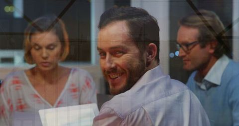 Business Team Analyzing Financial Data at Night with Digital Overlay