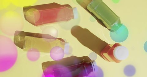 Vibrant assortment of fruit juices on yellow background