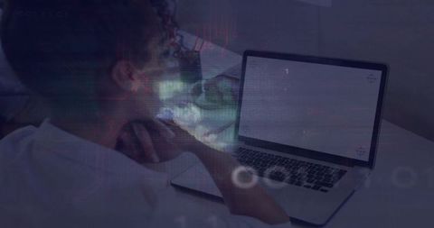 Mid-adult woman leaning on hand viewing laptop with HUD overlay in lowlight workspace