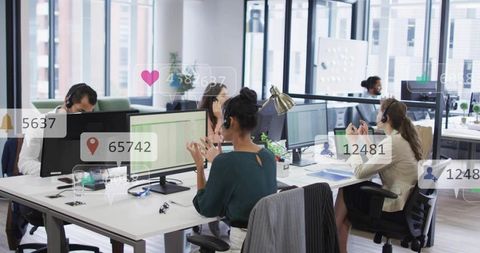 Customer Support Team Collaborating in Modern Open-Plan Office Using Headsets and Dual Monitors