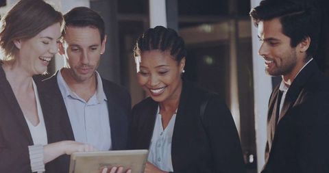 Diverse Business Team Collaborating with Tablet in Corporate Environment