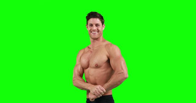 Muscular man smiling and posing shirtless against green screen. Great for fitness advertisements, workout programs, nutritional supplements, health blogs, gym promotions, and motivational content.
