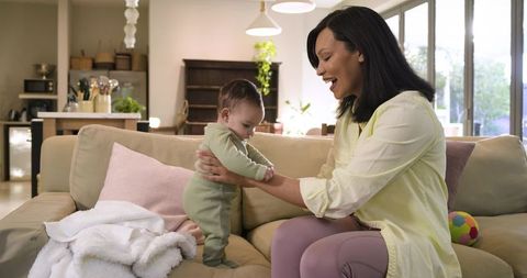 Mother Holding Baby Daughter in Modern Cozy Home Interior