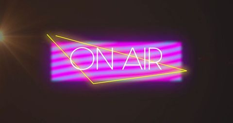 Neon 'on air' sign illuminating dark studio with retro vibe