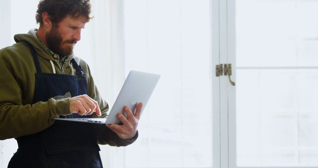 Handyman Using Laptop in Bright Room - Download Free Stock Images Pikwizard.com