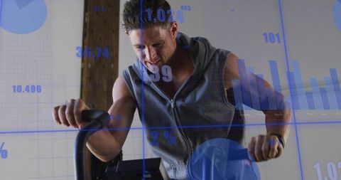 Fit man riding spin bike wearing sleeveless hoodie showing cardio analytics data overlay