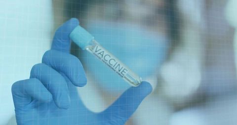 Healthcare Professional Holding Vaccine Vial in Clinical Laboratory