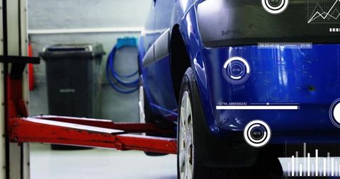 Blue car undergoing lift and digital diagnostics with hud readouts in auto repair bay