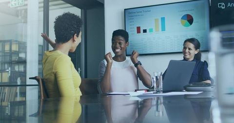 Celebrating Businesswoman in Meeting Room with Sales Graph Displayed