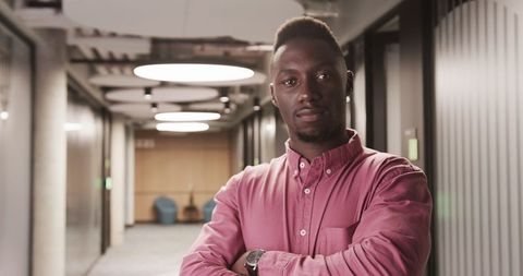 Confident Professional Standing in Modern Office Corridor