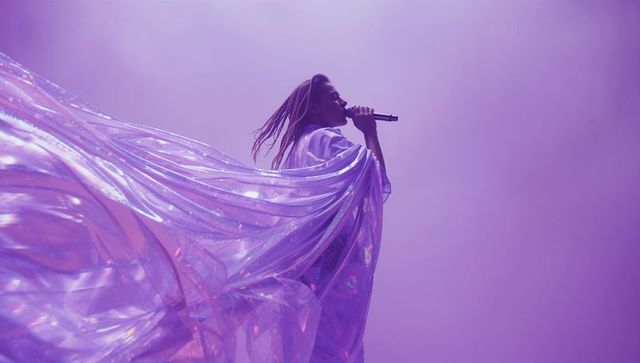 Glamorous Female Singer Performing on Stage with Flowing Iridescent Cape