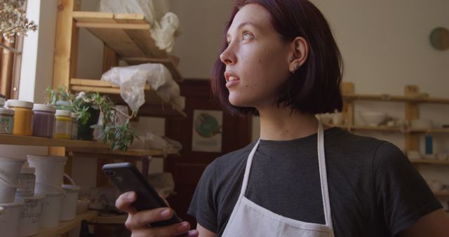 Young Woman in Pottery Studio Looking Out Window Contemplative - Download Free Stock Images Pikwizard.com