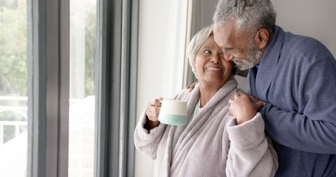 Happy Senior Couple Embracing by Window in Morning - Download Free Stock Images Pikwizard.com