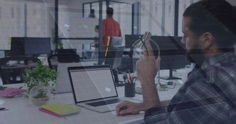 Businessman Gesturing Towards Laptop in Contemporary Office