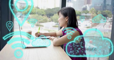 Korean woman working remotely in cafe with laptop, notebook and holographic cloud icons