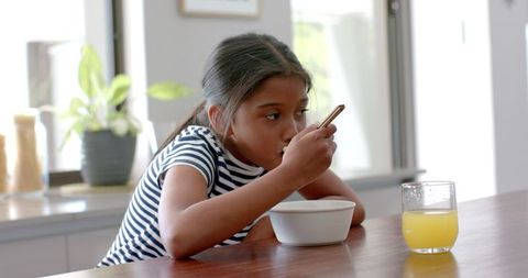 Young Girl Enjoys Healthy Breakfast at Home in Bright Kitchen