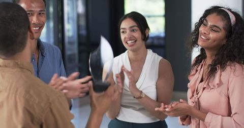 Diverse Team Celebrating Achievement with Award in Office