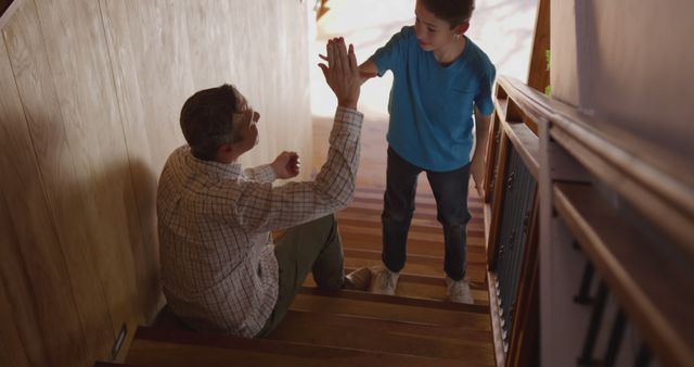 Father and Son Sharing a High-Five on Stairs - Download Free Stock Images Pikwizard.com