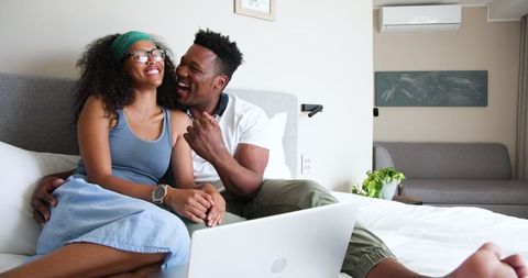Couple Sharing Pregnancy News Via Laptop in Cozy Home Ambience