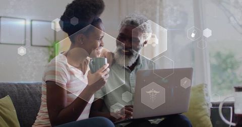 Happy Couple Using Laptop for Online Activity with Technology Graphics Overlay