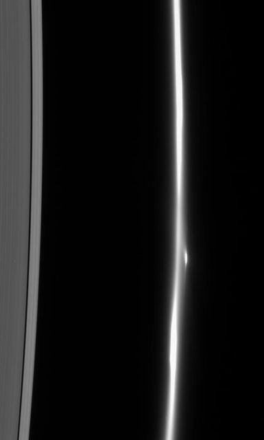 The F ring dissolves into a fuzzy stream of particles -- rather different from its usual appearance of a narrow, bright core flanked by dimmer ringlets. Also notable here is the bright clump of material that flanks the ring core
