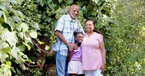 Grandparents with Granddaughter Amid Lush Garden Foliage